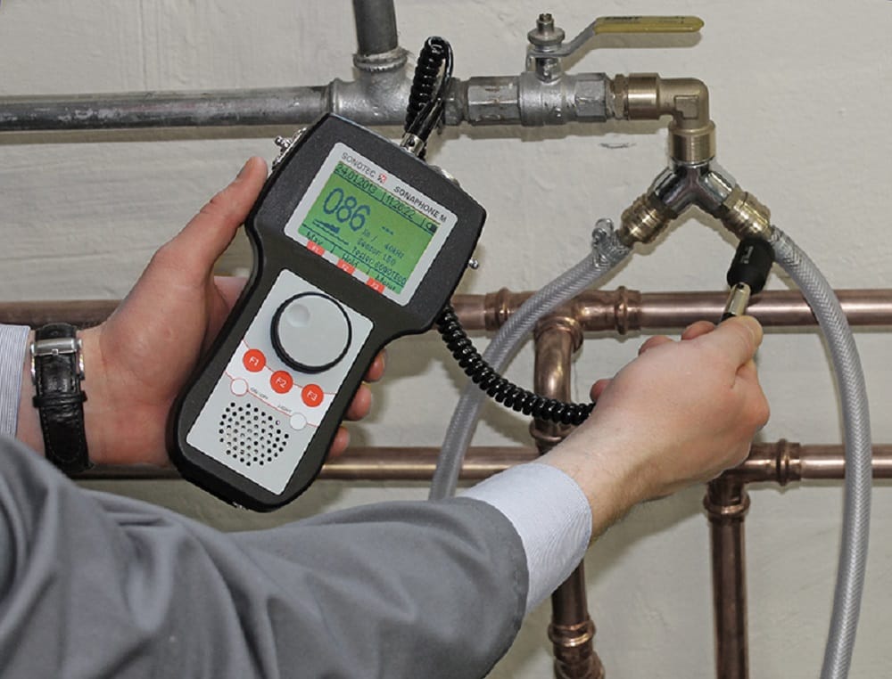 Plumber testing pipes with electronic leak detection equipment in Coral Springs
