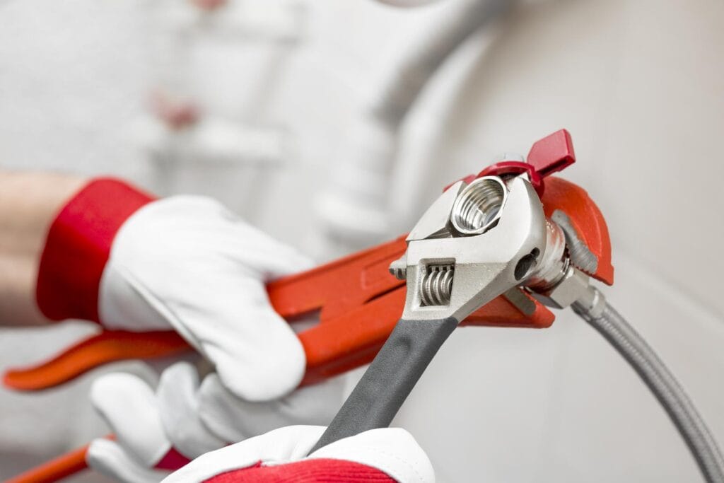 Plumber holding pipe wrenches for an emergency repair in Coral Springs