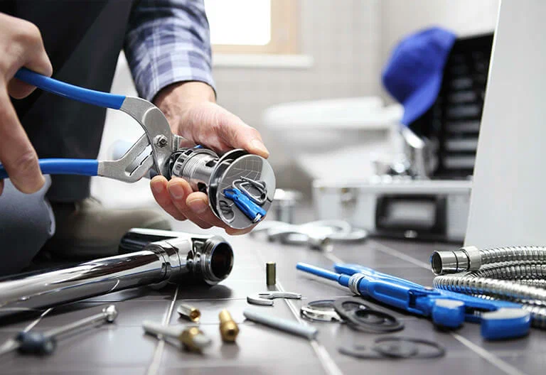Technician repairing a plumbing fixture with professional tools in Coral Springs