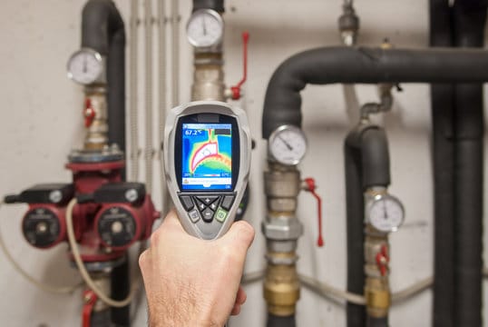 Plumber using a thermal imaging camera to inspect pipes in Coral Springs