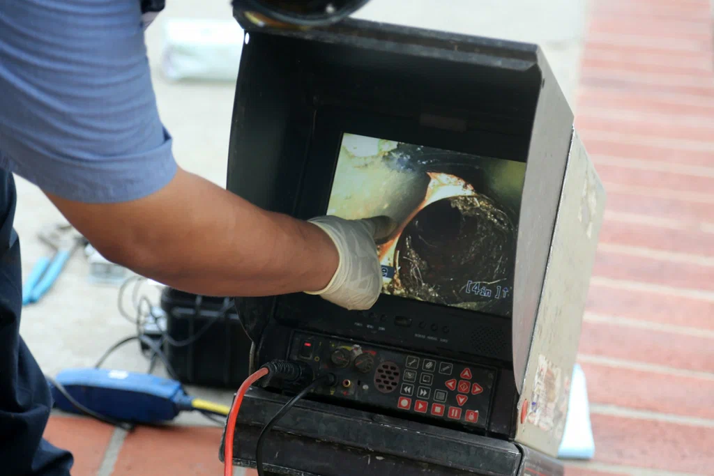 Technician viewing a drain inspection camera in Coral Springs