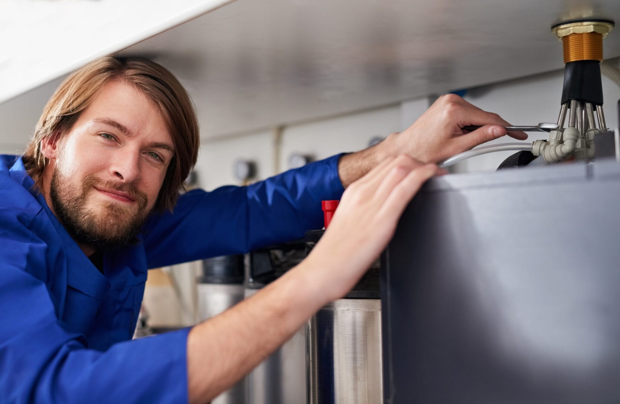 Technician servicing a residential water heater tank in Coral Springs