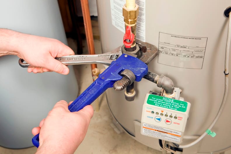Plumber repairing a water heater valve in Coral Springs